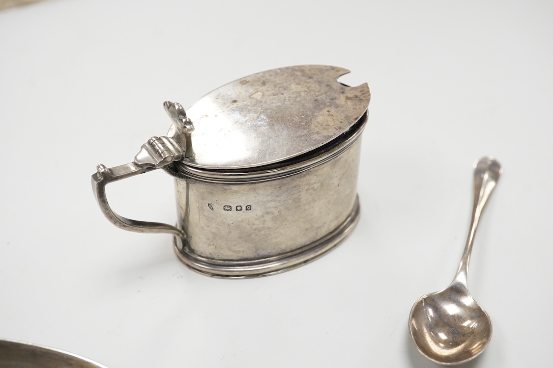 A William IV silver fiddle pattern table spoon by Richard Britton, London, 1834, together with a George V silver oval mustard pot, with blue glass liner, Edward Barnard Sons Ltd, London, 1931 and a silver coffee spoon.